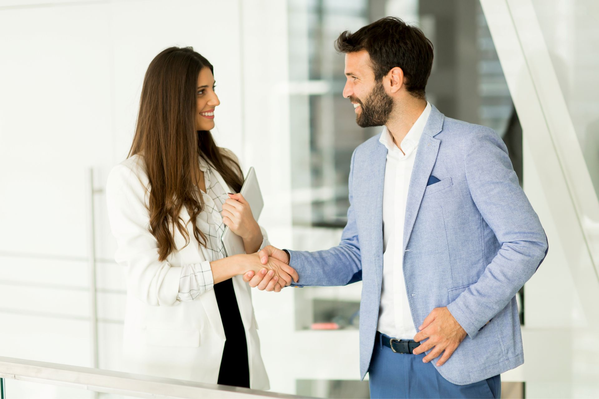 A man and a woman in business attire shaking hands
